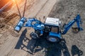 Blue excavator buries a hole top view