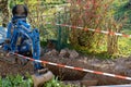 Blue excavator between temporary tape barrier in back yard. Royalty Free Stock Photo