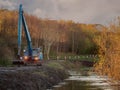 Blue excavator working on a river,