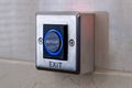 A modern exit button with a blue light on a white wall Royalty Free Stock Photo