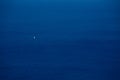 Blue expanse of water with a small yacht Royalty Free Stock Photo