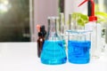 Blue experiment water in beaker and flask in chemistry science laboratory. Group of laboratory flasks with liquid inside Royalty Free Stock Photo