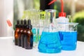 Blue experiment water in beaker and flask in chemistry science laboratory. Group of laboratory flasks with liquid inside. Royalty Free Stock Photo