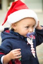 Blue eye baby girl profile. Christmas red hat, blue coat and pacifier dummy. New year rush. Hurry up for Xmas. Winter