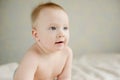 Blue-eyed baby sitting on the sofa Royalty Free Stock Photo