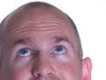 Blue Eyed Bald Man looking up one ear Royalty Free Stock Photo