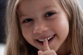 Blue-eyed blond girl laughs and shows the first tooth. children`s teeth, loss Royalty Free Stock Photo