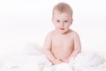 Blue eyed Blonde baby boy sitting on white cover