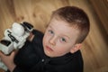 The blue-eyed boy looking up on wooden floor with a robot in the Royalty Free Stock Photo