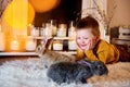 A blue eyed cute boy llooking smiling at the grey rabbits around Royalty Free Stock Photo