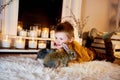 a blue eyed cute boy lying thoughtfully with grey rabbits around Royalty Free Stock Photo