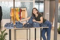 Blue-eyed girl chooses her blue jeans in the store. Royalty Free Stock Photo