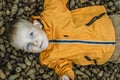 Blue Eyed Kid Laying on Ground with Pine Cone Background - Nephew in Park Royalty Free Stock Photo