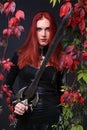 Blue Eyed Red Head Gothic Girl holding a fantasy sword among autumn vines