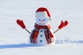 The blue eyed smiling snowman in red hat, gloves and plaid scarf holds the icicle in hand. Joyful cold winter morning. Royalty Free Stock Photo