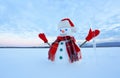 The blue eyed smiling snowman in red hat, gloves and plaid scarf holds the icicle in hand. Joyful cold winter morning. Royalty Free Stock Photo