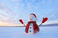 Blue eyed snowman. Sunrise enlightens the sky and clouds by warm colors. Reflecting on the snow. Mountains landscape.