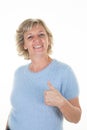 Blue eyes blonde beautiful and smiling senior woman thumb up looking confident Royalty Free Stock Photo