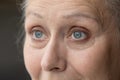 Blue eyes of thoughtful senior 70 woman looking away