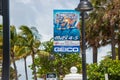 Blue fabric sign on a lamp post advertising the Fort Lauderdale Air Show that took place on May 4th and 5th. There are palm trees