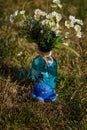Blue fabric sof octopus toy on green grass, vase with white artificial flowers. Sea animals concept.