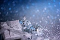 Blue festive Christmas background with defocused lights, gift box and shiny balls. Royalty Free Stock Photo