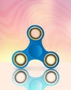 Blue fidget spinner on bright background. Royalty Free Stock Photo