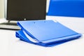 Blue file folder with documents and Notebook on the white table Royalty Free Stock Photo