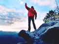 Blue filtered photo. Man in red jacket thinking at rock cliff. Melancholy evening in nature. Royalty Free Stock Photo