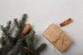 Blue fir tree branch with big cone, wrapped present box and cinnamon sticks on white wooden background. Christmas blank card, copy Royalty Free Stock Photo