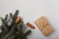 Blue fir tree branch with big cone, wrapped present box and cinnamon sticks on white wooden background. Christmas blank card, copy Royalty Free Stock Photo