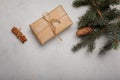 Blue fir tree branch with big cone, wrapped present box and cinnamon sticks on white wooden background. Christmas blank card, copy Royalty Free Stock Photo