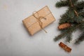 Blue fir tree branch with big cone, wrapped present box and cinnamon sticks on white wooden background. Christmas blank card, copy Royalty Free Stock Photo