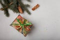 Blue fir tree branch with big cone, wrapped present box and cinnamon sticks on white wooden background. Christmas blank card, copy Royalty Free Stock Photo