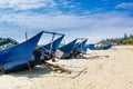 Blue fishing boat on the sand beach against blue and white cloudy sky in Yangxi, Yangjiang, Guangdong, China Royalty Free Stock Photo