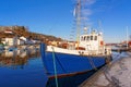 Blue fishing boat with a wooden mast