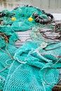 Blue fishing net on a pontoon with its ropes and floats covered with morning frost Royalty Free Stock Photo