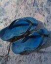 blue flip-flops that are dull from being used so often