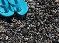 Blue flip-flops are standing on the wet pebbles. Royalty Free Stock Photo