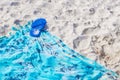 Blue flipflops on blue beach blanket towel on white sand Royalty Free Stock Photo