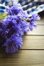 Blue flowers of cornflowers, rustic bouquet picked in summer located on wooden brown background Royalty Free Stock Photo