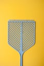 blue fly swatter on yellow background Royalty Free Stock Photo