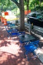 Blue folding chairs and tables arranged under patio umbrella in sunny courtyard Royalty Free Stock Photo