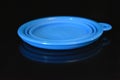 Blue folding and multifunctional rubber plate, a bowl with a plastic edging on a black glossy surface.