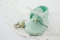 Blue fondant sugar shape baby bootees and silver charms on white lace background