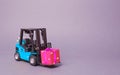 Blue forklift truck carries a pink gift box with a bow. Purchase and delivery of a present. retail, discounts and contests Royalty Free Stock Photo