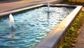 Blue fountain with a gush of running water in a common Italian square Royalty Free Stock Photo