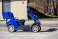 Blue four wheeled mobility scooter for eldery or disabled person on the road in the city