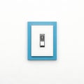 Blue framed wall light switch set against a plain background Royalty Free Stock Photo