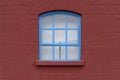 Blue Framed Window with Arch in a Brick Wall